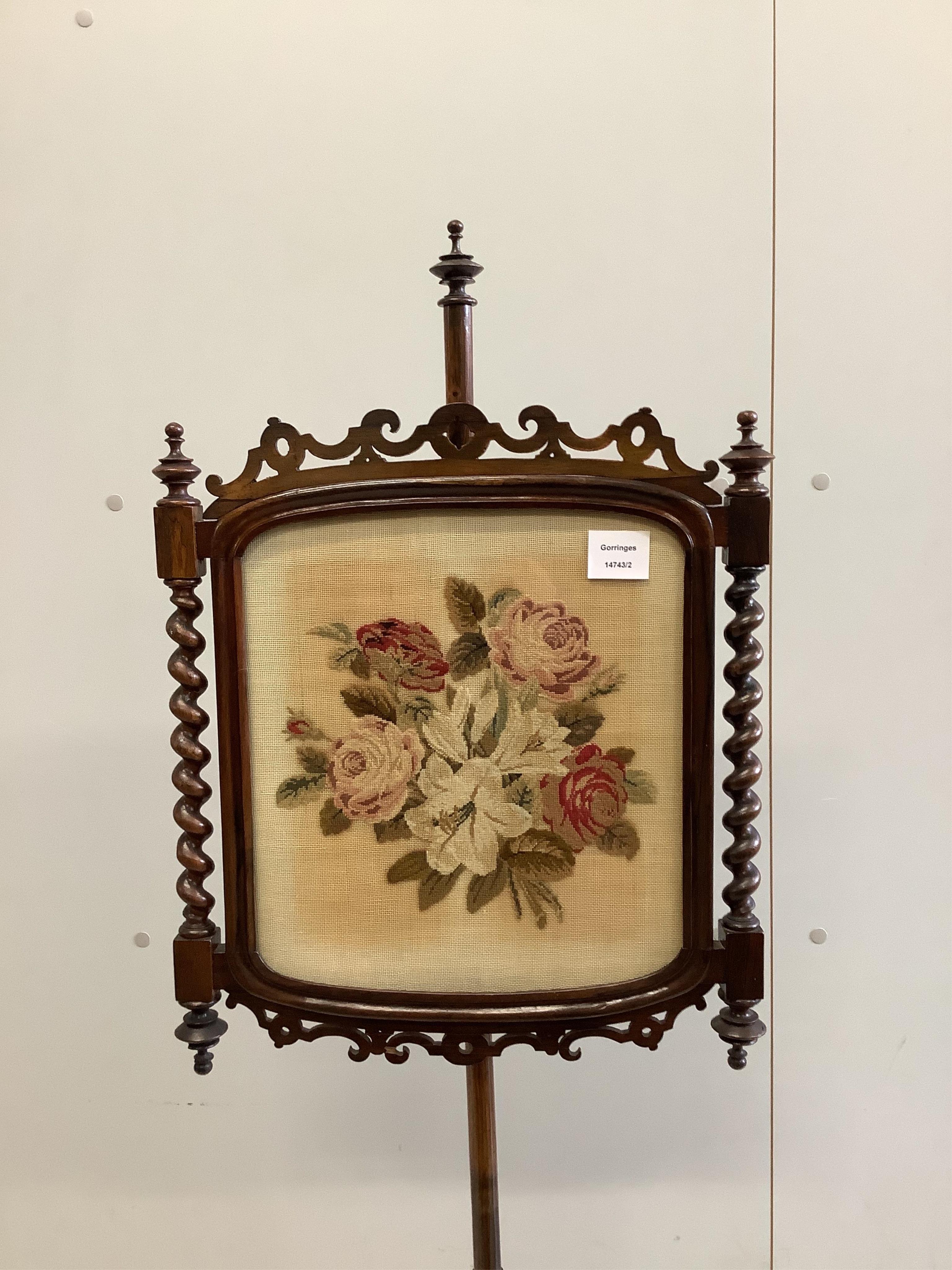A pair of Victorian rosewood pole screens with floral tapestry banners, height 150cm. Condition - fair